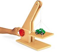 a wooden toy with a green car on it and a red ball in the middle