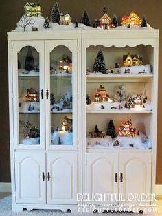 a white china cabinet filled with lots of christmas decorations on top of snow covered shelves