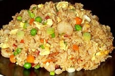 a pile of rice with peas and carrots