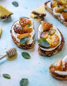 toasted bread topped with fruit and cream on top of a blue plate next to lemon wedges