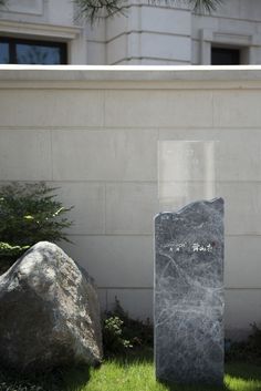 two large rocks sitting next to each other in front of a building