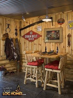 there are three stools at the table in this log cabin dining room with wood paneling