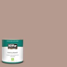 the behr paint and primer is shown in an open, beige - colored tin