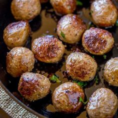 some meatballs are cooking in a skillet