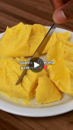 a person cutting up some food on a white plate