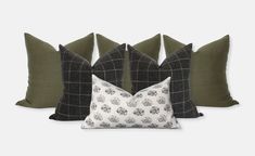 four pillows with different patterns on them, one in black and the other in green