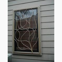 a window that is on the side of a house with an iron screen behind it