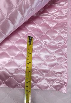 a pink quilt with a measuring tape on it