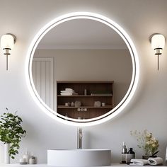 a bathroom with a round mirror above the sink and lights on the wall next to it