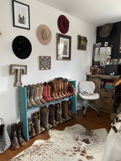 a room filled with lots of boots and hats hanging on the wall next to a chair