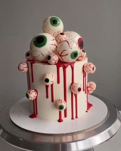 a white cake with red icing and spooky eyes on it's side