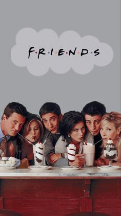 friends sitting at a table with cake and milkshakes in front of their faces