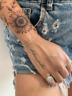 a woman's arm with a sunflower tattoo on the left side of her body