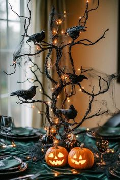 a table topped with two pumpkins and birds sitting on top of it's branches