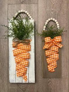 two pieces of wood are decorated with orange and white gingham bows