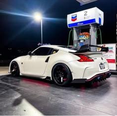 a white nissan sports car at a gas station