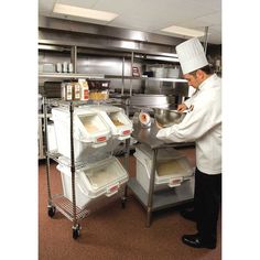 a man in a kitchen preparing food on top of metal trays and pans