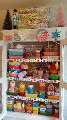 an open cabinet filled with lots of colorful dishes and candy on top of each other