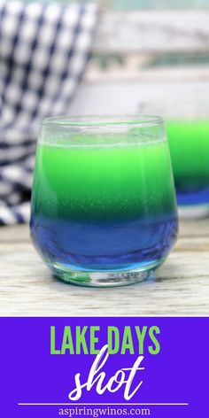 two glasses filled with green and blue liquid on top of a wooden table next to the words lake days shot