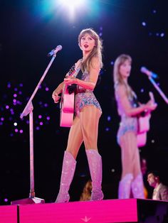 taylor swift performing on stage with her guitar