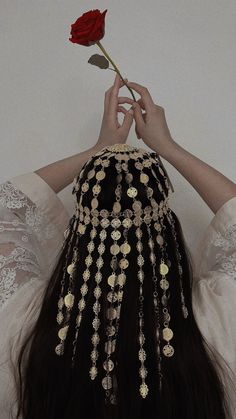 A girl using traditional kaftan dress in light colors and a traditional gold coin headpiece holds a rose. Ancient Egyptian Hair, Ancient Egyptian Hairstyles, Traditional Headpiece, Egyptian Hair, Khaleeji Aesthetic, Egyptian Hairstyles, Egyptian Wedding, Arabic Clothing, Arabic Jewelry