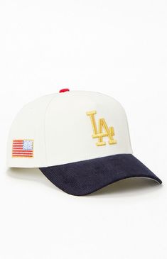 the los angeles dodgers baseball cap is shown in white and navy blue with gold lettering