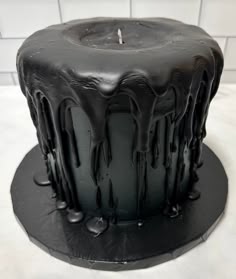 a black cake with chocolate icing on top