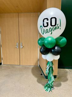 balloons and streamers are on the floor in front of a door that says go dragon