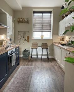 a kitchen filled with lots of counter top space and white cabinets next to a window