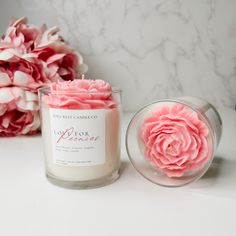 a pink flower sitting next to a candle