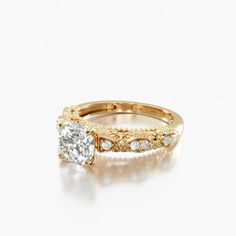 a yellow gold engagement ring with an oval cut diamond in the center and side stones