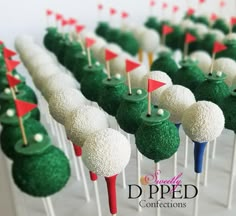 green and white cake pops with golf flags on them are ready to be served for guests