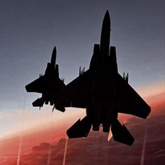 a fighter jet flying through the sky at sunset