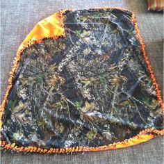 an orange and black blanket sitting on top of a floor