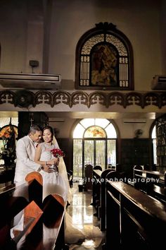 the bride and groom are posing for a photo in front of pews at their wedding ceremony