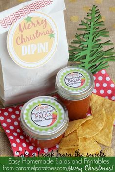 three jars of homemade salsa next to a bag of chips on a red and green tablecloth