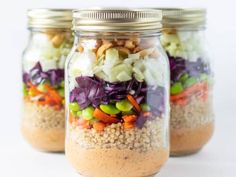 three mason jars filled with different types of salads and nuts on top of each other