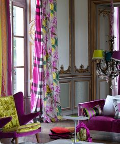 a living room filled with lots of purple furniture