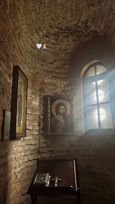 an old room with paintings on the wall and a small table in front of it