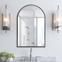 a bathroom sink sitting under a mirror next to a wall mounted faucet with lights on it