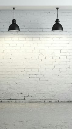 three black lights are hanging over a white brick wall