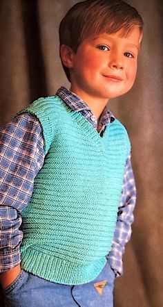 a young boy wearing a blue sweater vest