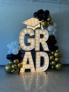 the letters grad are lit up with balloons