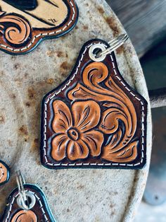 Tooled Eartag Keychain.  Handmade by Maker: Lauren McDowell Herman Oak Leather 🇺🇸 Tooled Leather Keychain Ideas, Leather Tooled Keychains, Leather Work Projects, Leather Keychain Ideas, Small Leather Projects, Leather Christmas Ornaments, Tooled Leather Keychain, Diy Leather Working, Custom Leather Work