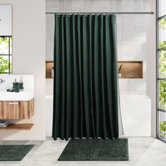 a bathroom with a green shower curtain and rugs in front of the bathtub