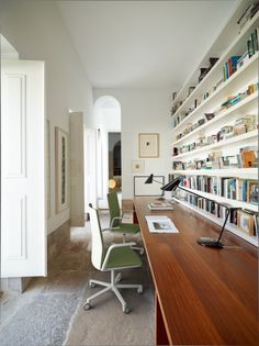 an office with bookshelves, desk and chairs