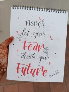 a hand holding up a notebook with the words never let your team decide your future