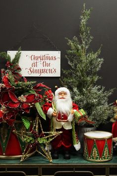 a christmas scene with santa claus and other decorations on a table next to a tree