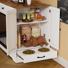 an open cabinet with two stuffed animals and food on the bottom shelf next to it