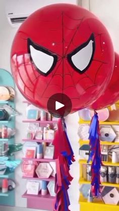 a spiderman balloon is hanging from the ceiling in a room with shelves and other items